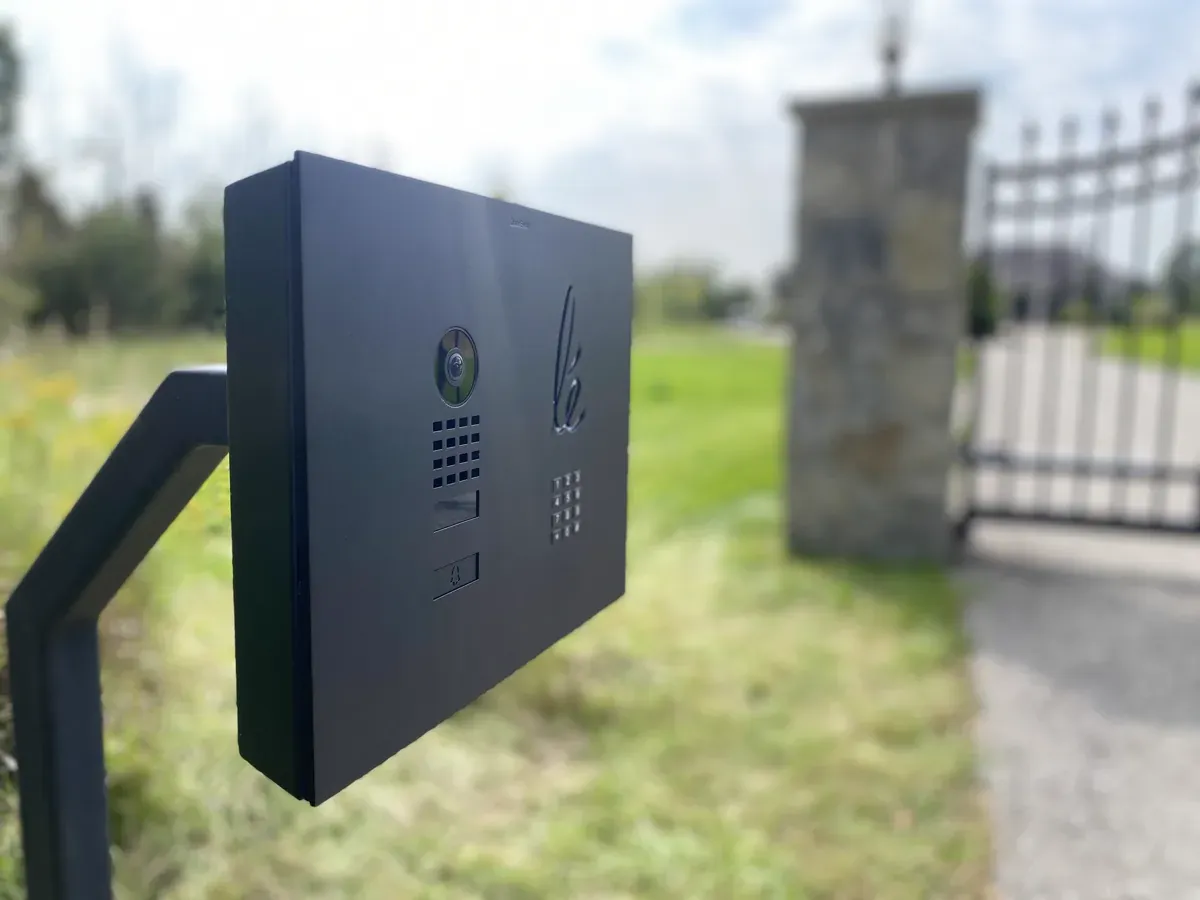 DoorBird video intercom and keypad panel mounted at an estate gate entrance