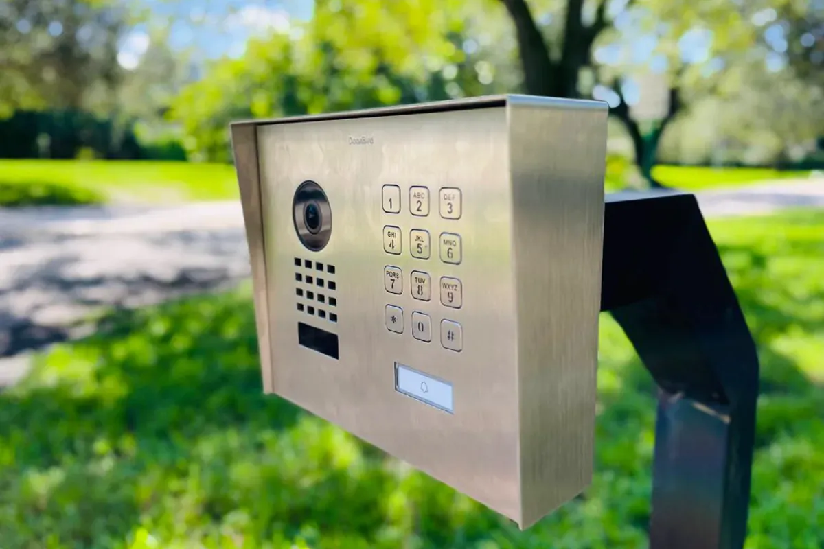 Pedestal-mounted entry panel with a physical keypad at a driveway