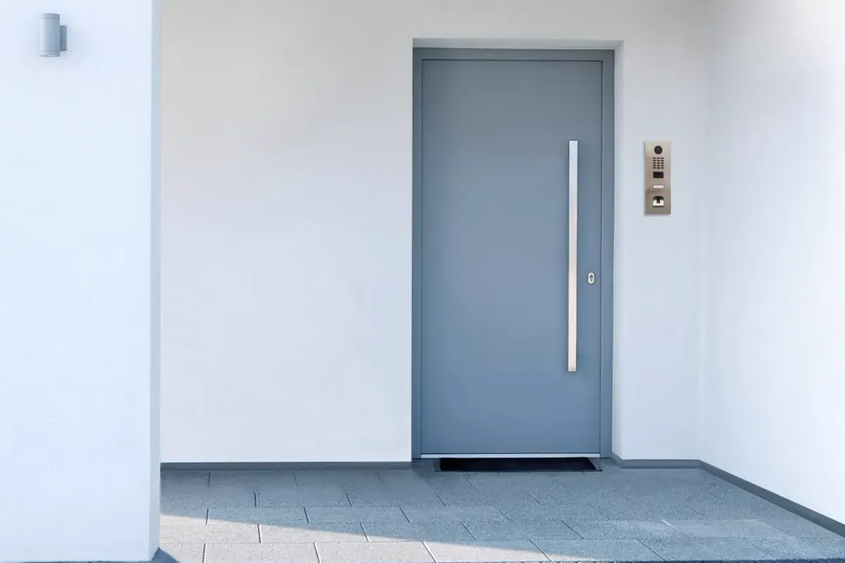 Video intercom panel mounted beside a modern entrance door